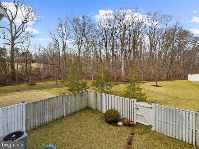 view of yard featuring central AC unit, fence private yard, and a gate