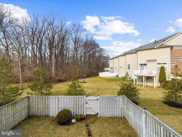 view of yard with a fenced backyard and a gate