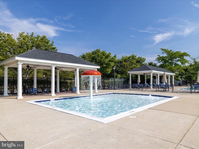 community pool with a ceiling fan, a gazebo, fence, and a patio area