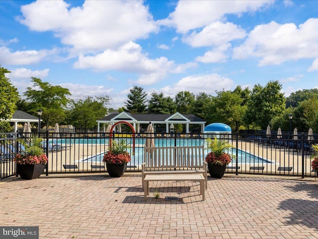 community pool with a gazebo, a patio area, and fence