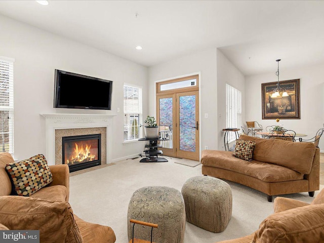 living room with baseboards, a fireplace with flush hearth, carpet floors, recessed lighting, and a notable chandelier