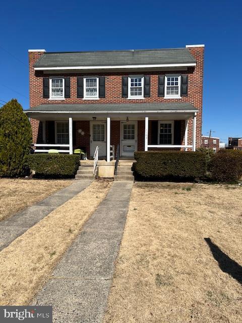 view of front facade featuring covered porch and brick siding