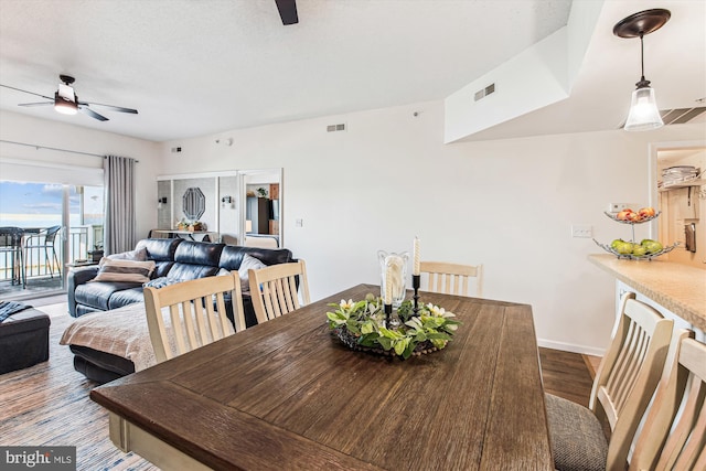 dining area featuring visible vents, a ceiling fan, and wood finished floors