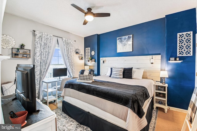 carpeted bedroom featuring baseboards, a textured ceiling, and a ceiling fan