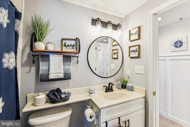 bathroom with tile patterned flooring, toilet, and vanity