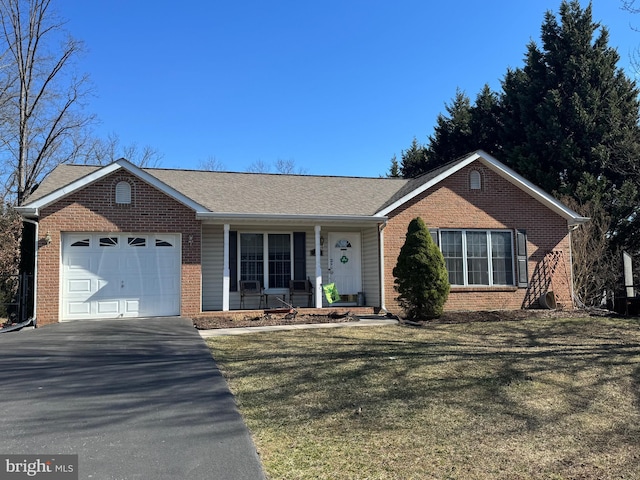 ranch-style house with aphalt driveway, brick siding, covered porch, an attached garage, and a front lawn