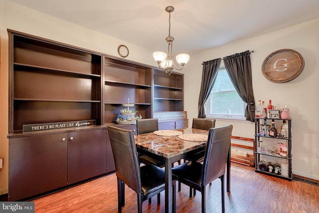 dining room with visible vents, wood finished floors, and a notable chandelier