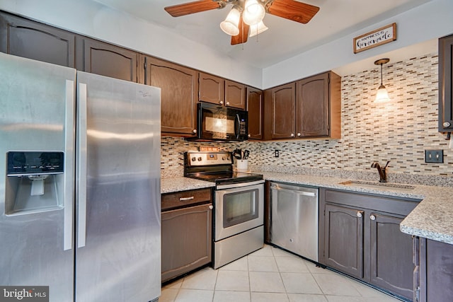 kitchen featuring light tile patterned floors, tasteful backsplash, a sink, stainless steel appliances, and a ceiling fan