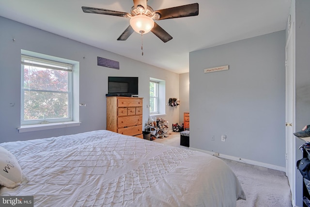 carpeted bedroom with ceiling fan, lofted ceiling, and baseboards