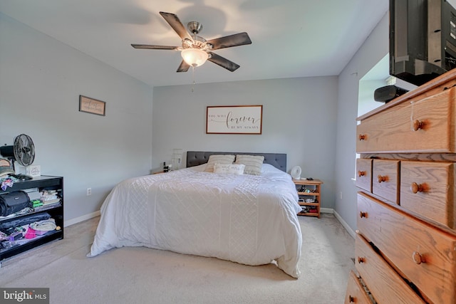 carpeted bedroom with ceiling fan and baseboards
