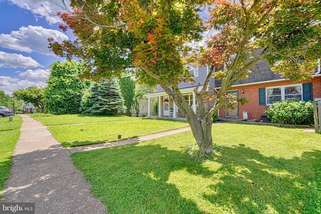 view of front of home featuring a front yard and brick siding