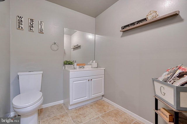 half bath with baseboards, tile patterned floors, toilet, and vanity