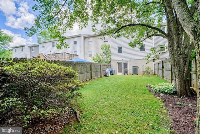 view of yard with central AC and a fenced backyard