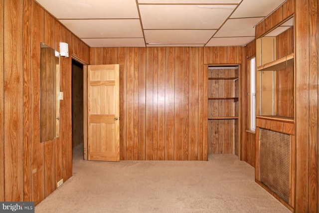 empty room with carpet flooring and wood walls