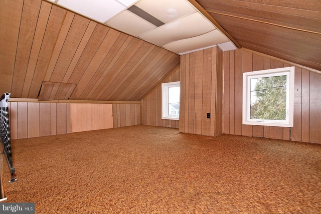 bonus room featuring vaulted ceiling, wooden walls, and carpet floors