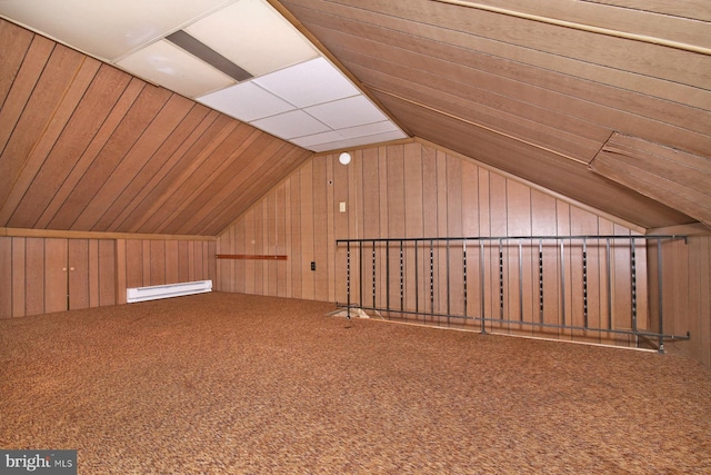 additional living space featuring a baseboard heating unit, lofted ceiling, wooden walls, and carpet flooring