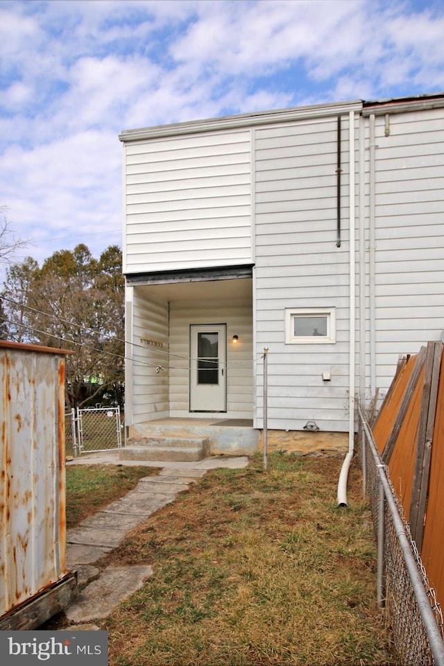 view of outbuilding featuring fence and a gate