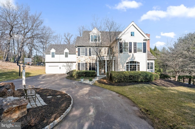 view of front of home featuring driveway, an attached garage, and a front yard