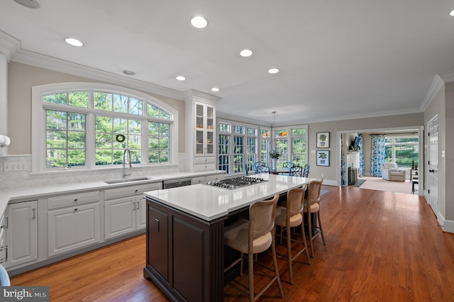 kitchen featuring a sink, stainless steel appliances, ornamental molding, and white cabinets