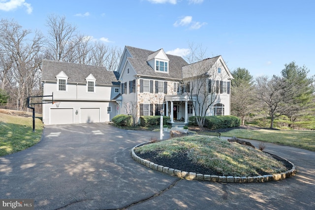 georgian-style home featuring aphalt driveway and an attached garage