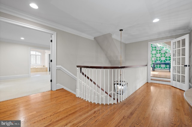 interior space with wood finished floors, an upstairs landing, ornamental molding, and recessed lighting