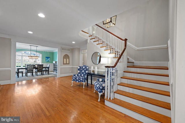 stairway featuring recessed lighting, visible vents, wood finished floors, and crown molding