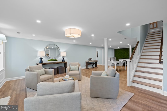 living area featuring recessed lighting, stairway, visible vents, and wood finished floors