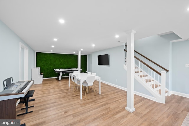 dining space featuring baseboards, recessed lighting, stairs, an accent wall, and light wood-type flooring