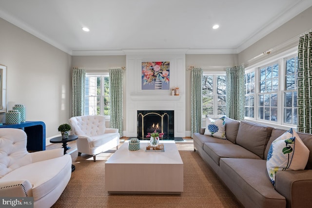 living area featuring recessed lighting, a warm lit fireplace, crown molding, and baseboards