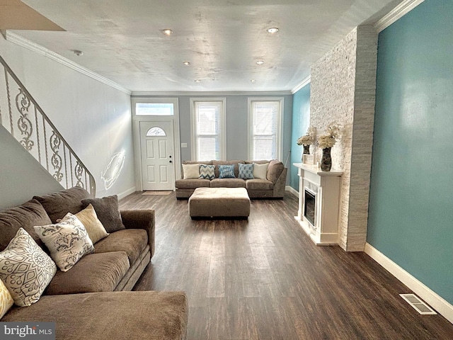 living room featuring visible vents, dark wood-type flooring, a fireplace, crown molding, and baseboards