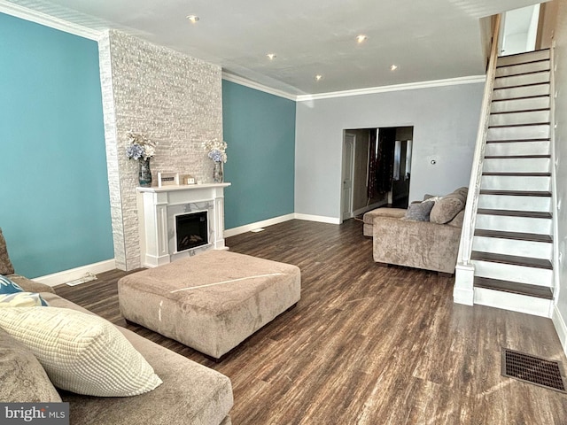 living room featuring visible vents, wood finished floors, ornamental molding, and stairway