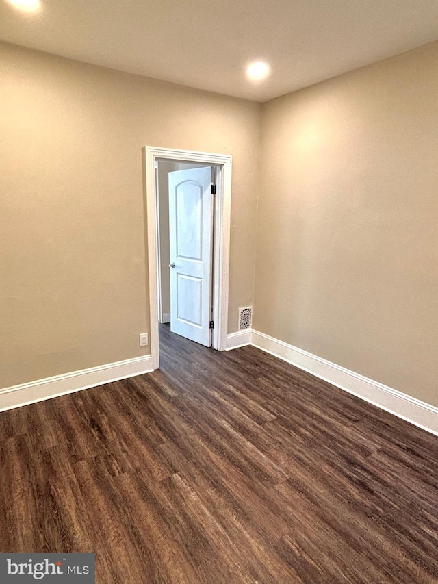 spare room with dark wood-type flooring, recessed lighting, baseboards, and visible vents