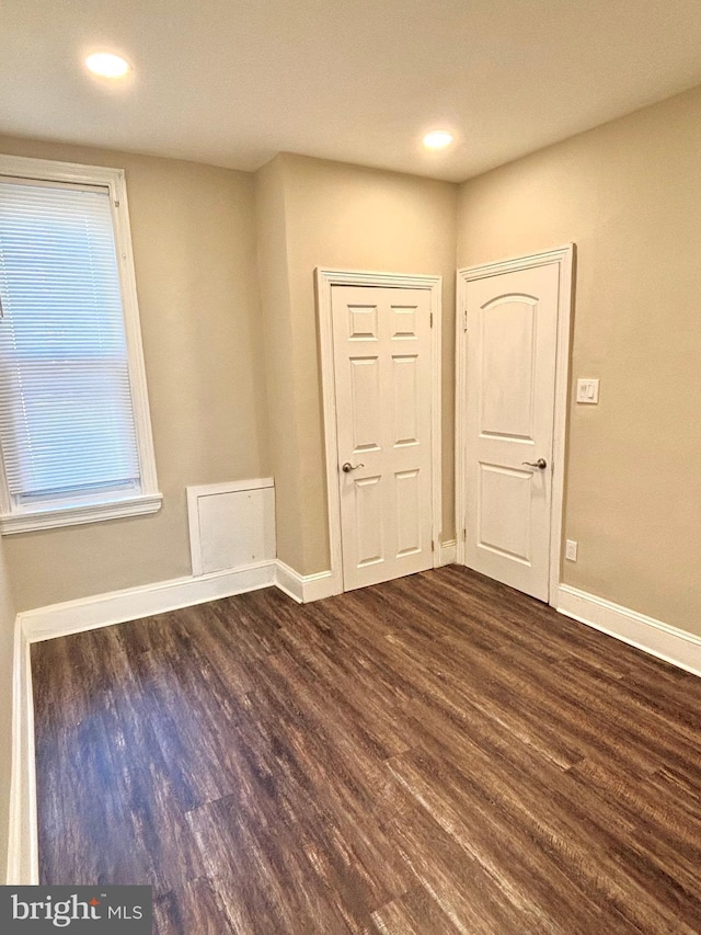 empty room featuring recessed lighting, baseboards, and dark wood finished floors