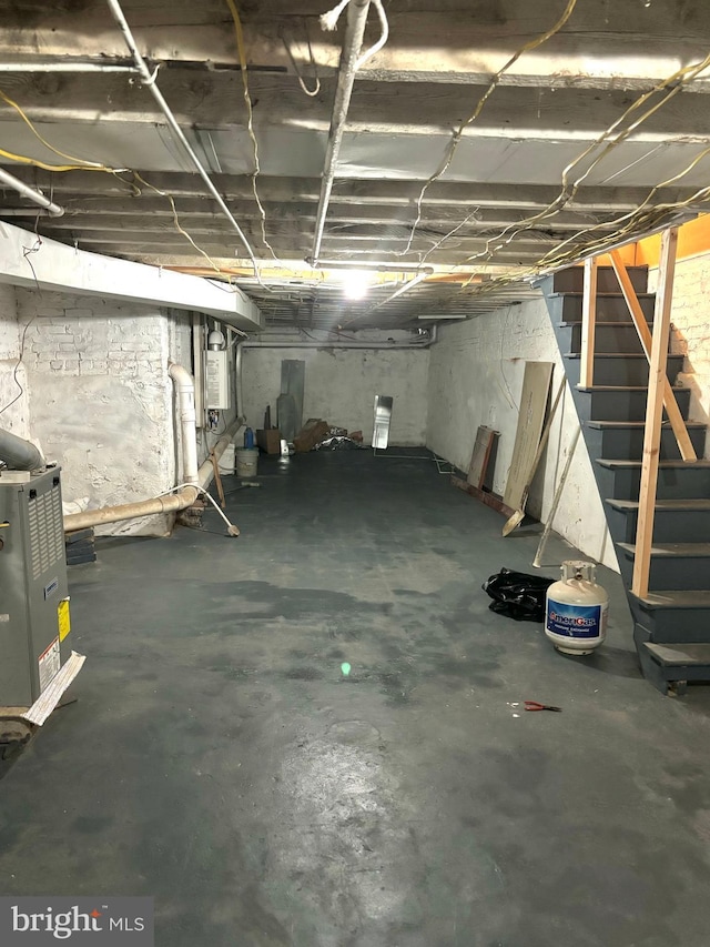 unfinished basement with stairway and water heater