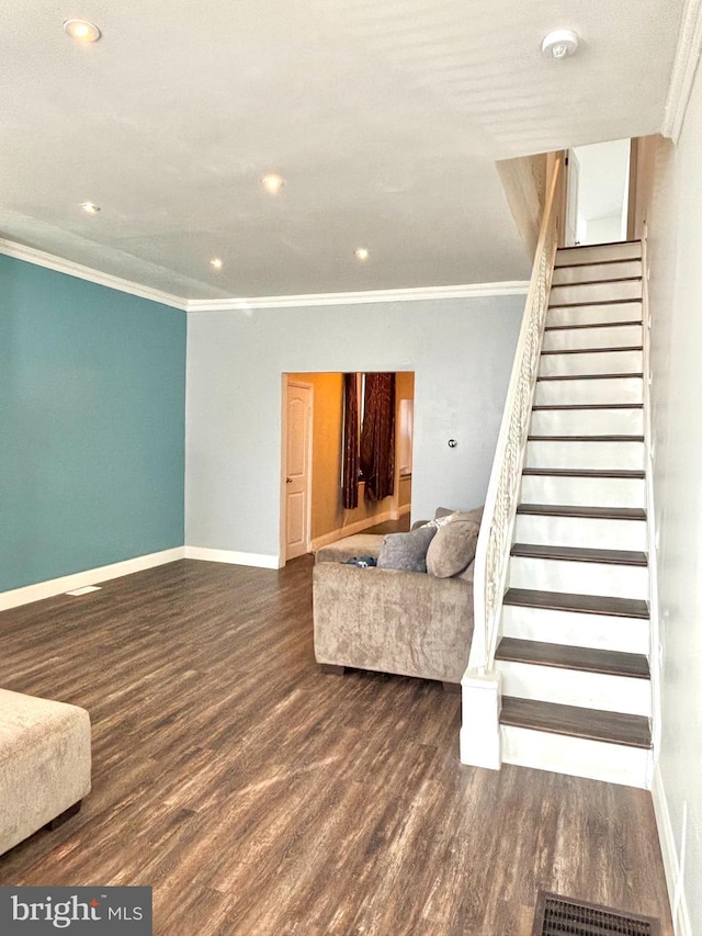 unfurnished living room featuring visible vents, ornamental molding, wood finished floors, baseboards, and stairs