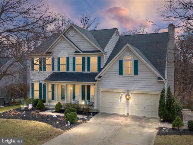 view of front of home with an attached garage, covered porch, driveway, and a chimney