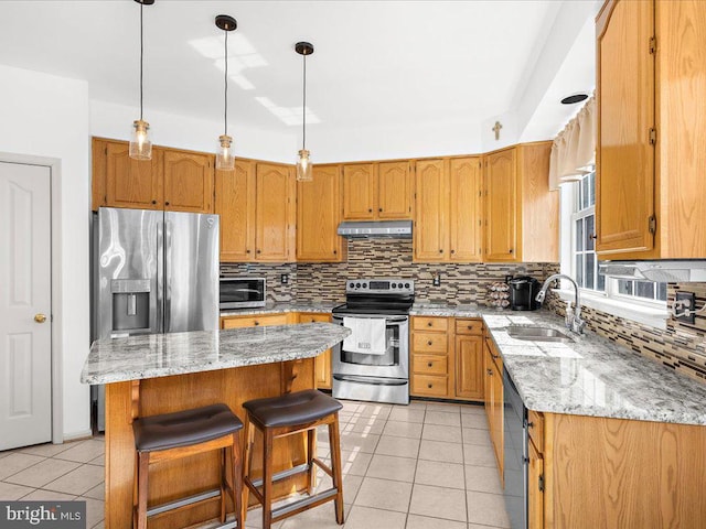 kitchen featuring under cabinet range hood, decorative backsplash, light tile patterned flooring, stainless steel appliances, and a sink