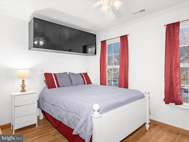 bedroom featuring a ceiling fan, wood finished floors, baseboards, and ornamental molding