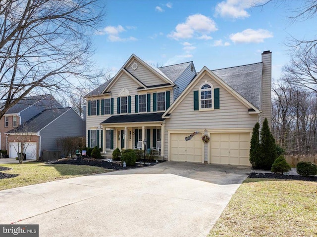 view of front facade with covered porch, concrete driveway, an attached garage, a front yard, and a chimney