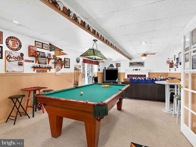 playroom featuring carpet flooring, a paneled ceiling, a wainscoted wall, and wood walls