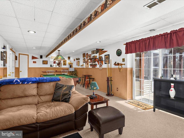 living room featuring a wainscoted wall, visible vents, carpet, and a drop ceiling