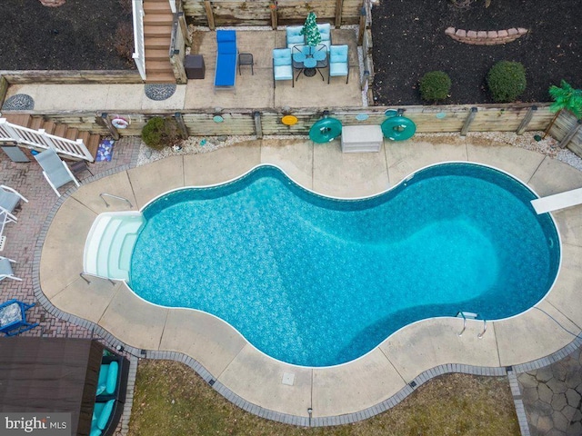 view of swimming pool featuring a diving board and a patio area