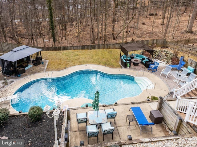 view of swimming pool featuring a patio, a fenced in pool, a fenced backyard, outdoor lounge area, and a lawn