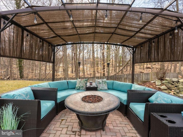 view of patio / terrace with an outdoor living space with a fire pit and fence