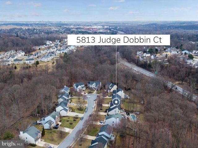 drone / aerial view with a residential view and a wooded view