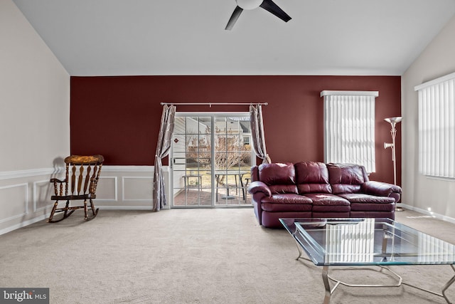 living area featuring plenty of natural light, ceiling fan, carpet flooring, and vaulted ceiling