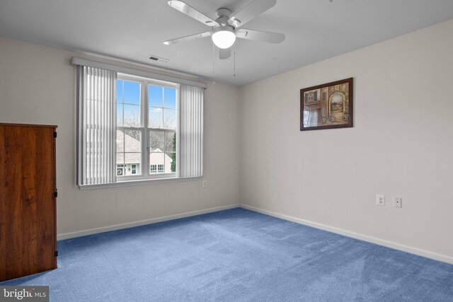 spare room featuring baseboards, visible vents, carpet floors, and ceiling fan