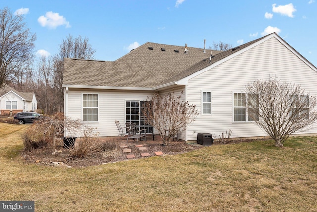 rear view of property featuring a patio area, a lawn, and roof with shingles