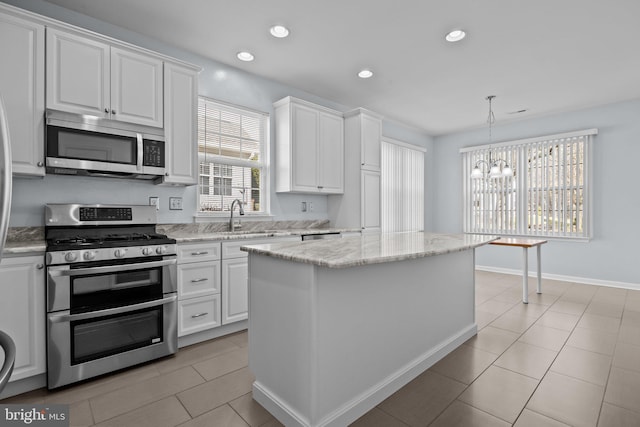 kitchen with light stone counters, recessed lighting, white cabinets, stainless steel appliances, and a sink