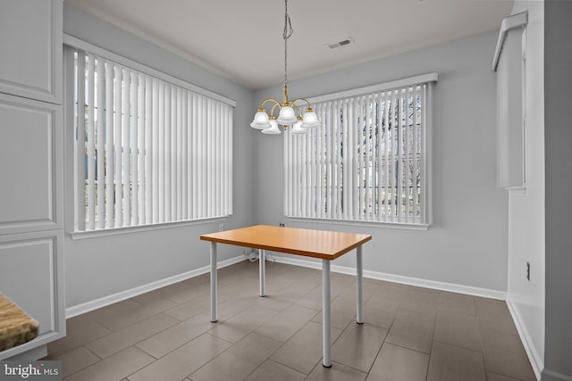 unfurnished dining area featuring a notable chandelier, visible vents, and baseboards